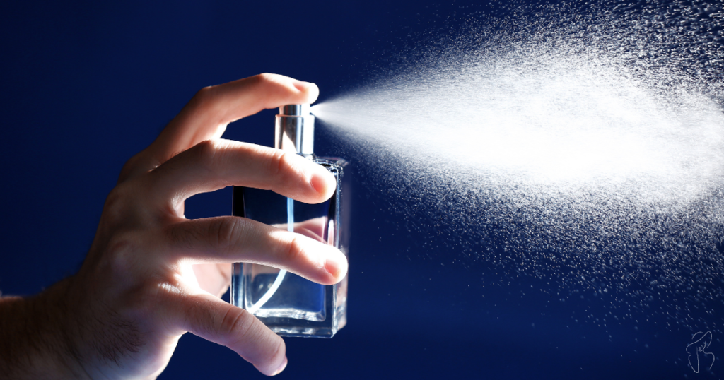 A close-up photo of a hand spraying a silver perfume bottle with a blue nozzle indicating  is this  according to the Fragrance Wheel?