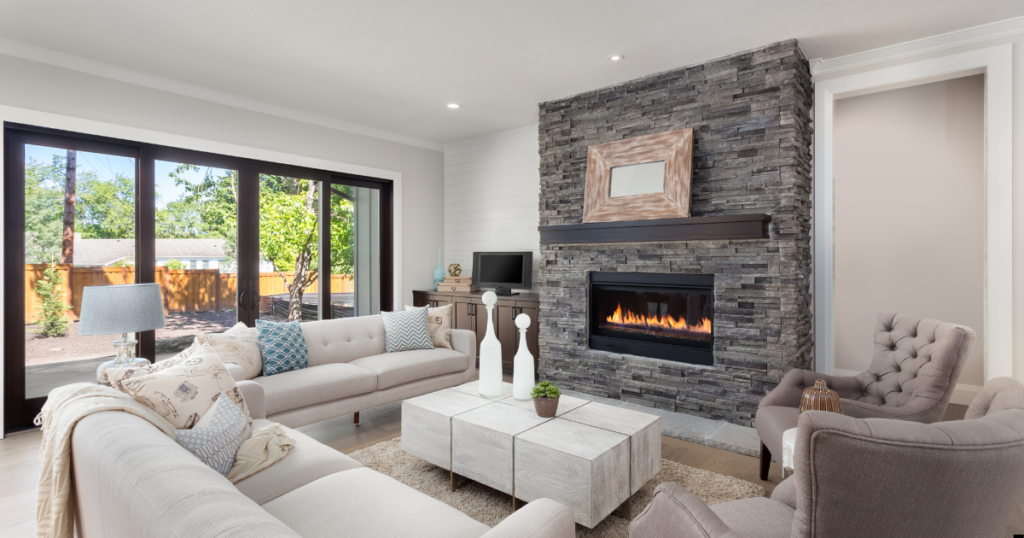 A living room with a fireplace, couch, and chairs.