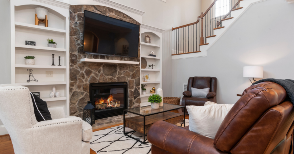 A well-lit living room with a fireplace and a flat screen TV.