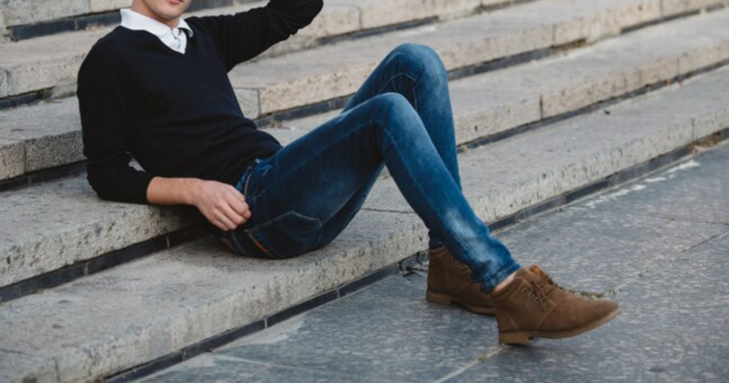 A man in a suit sitting on steps,wearing Rugged Brown Leather Boot 