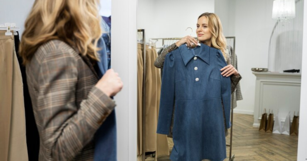 A woman examining a coat in a store, carefully inspecting the fabric and design